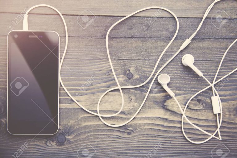 Pueden los audios de WhatsApp ser utilizados como prueba legal 6 audifonos y telefono movil sobre una mesa