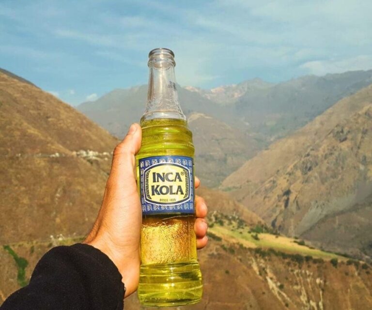 Qué es la famosa bebida gaseosa amarilla del Perú 11 botella de bebida amarilla en un paisaje peruano