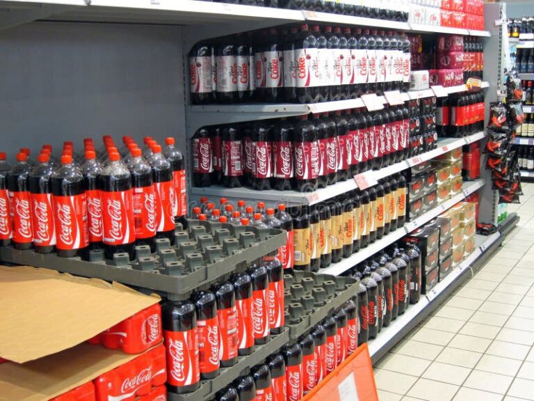 Qué giro y tamaño tiene la empresa Coca-Cola en el mercado 50 botellas de coca cola en estantes de tienda