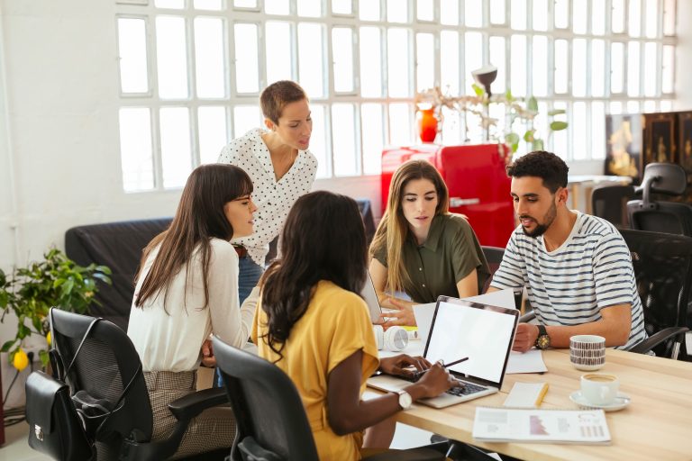 Cómo organizar eficazmente el trabajo, actividades y tareas en equipo 11 equipo colaborando en una mesa de trabajo 1
