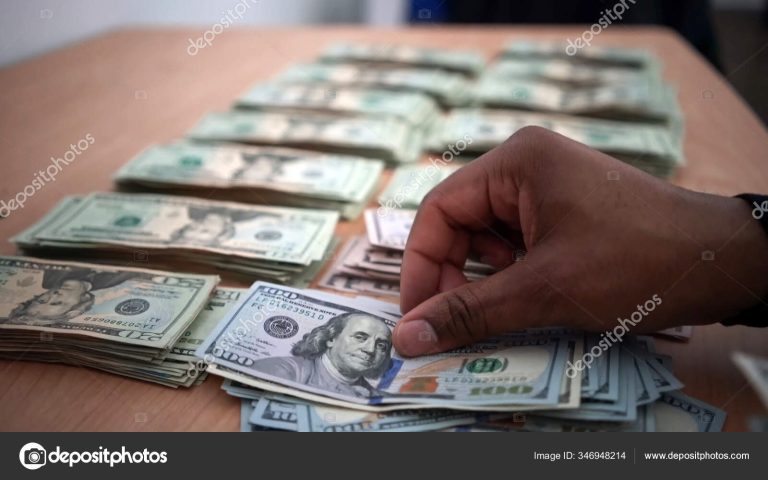 manos contando billetes en una mesa