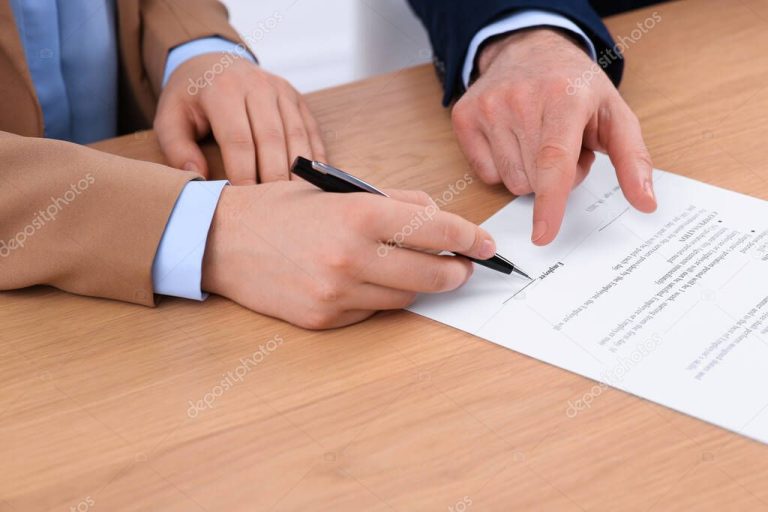 manos firmando un contrato en la mesa