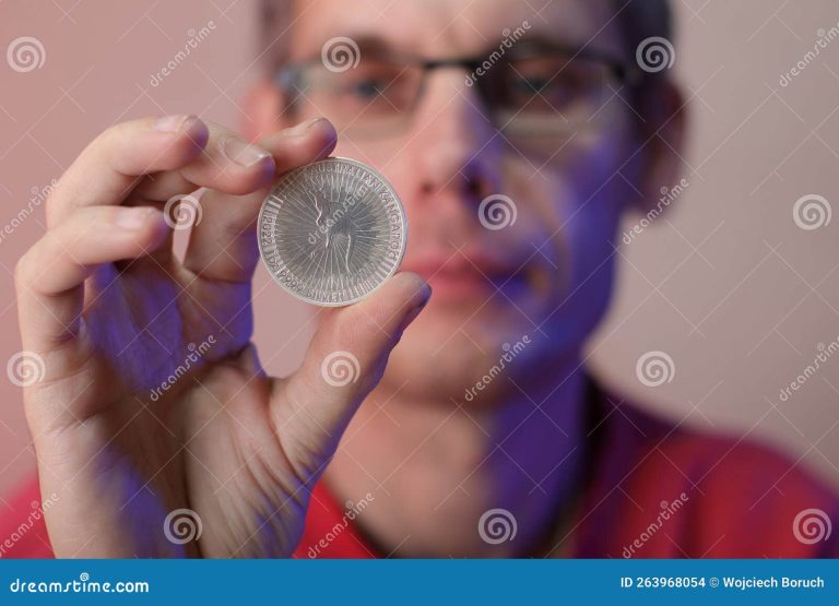 monedas en una mano sobre fondo colorido