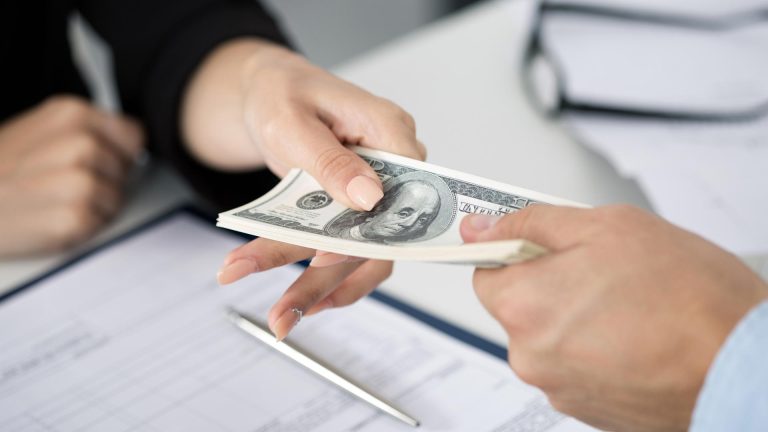 Puede otra persona cobrar mi devolución de impuestos en México 8 persona recibiendo dinero en una oficina