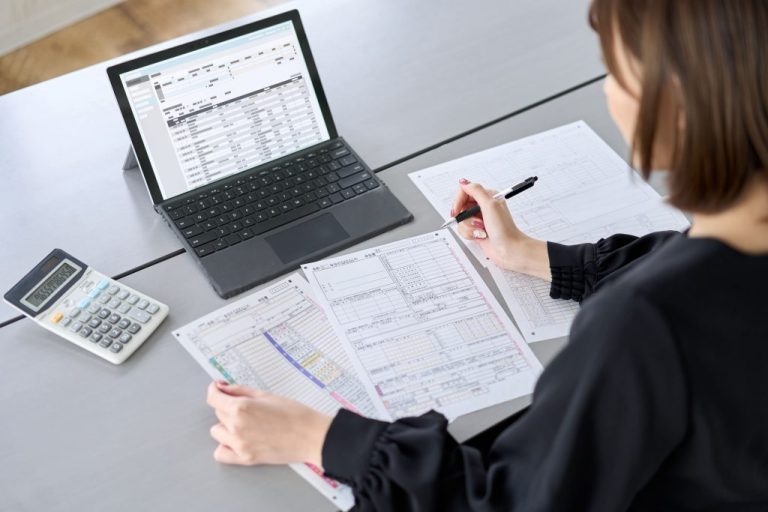 persona usando computadora con documentos fiscales